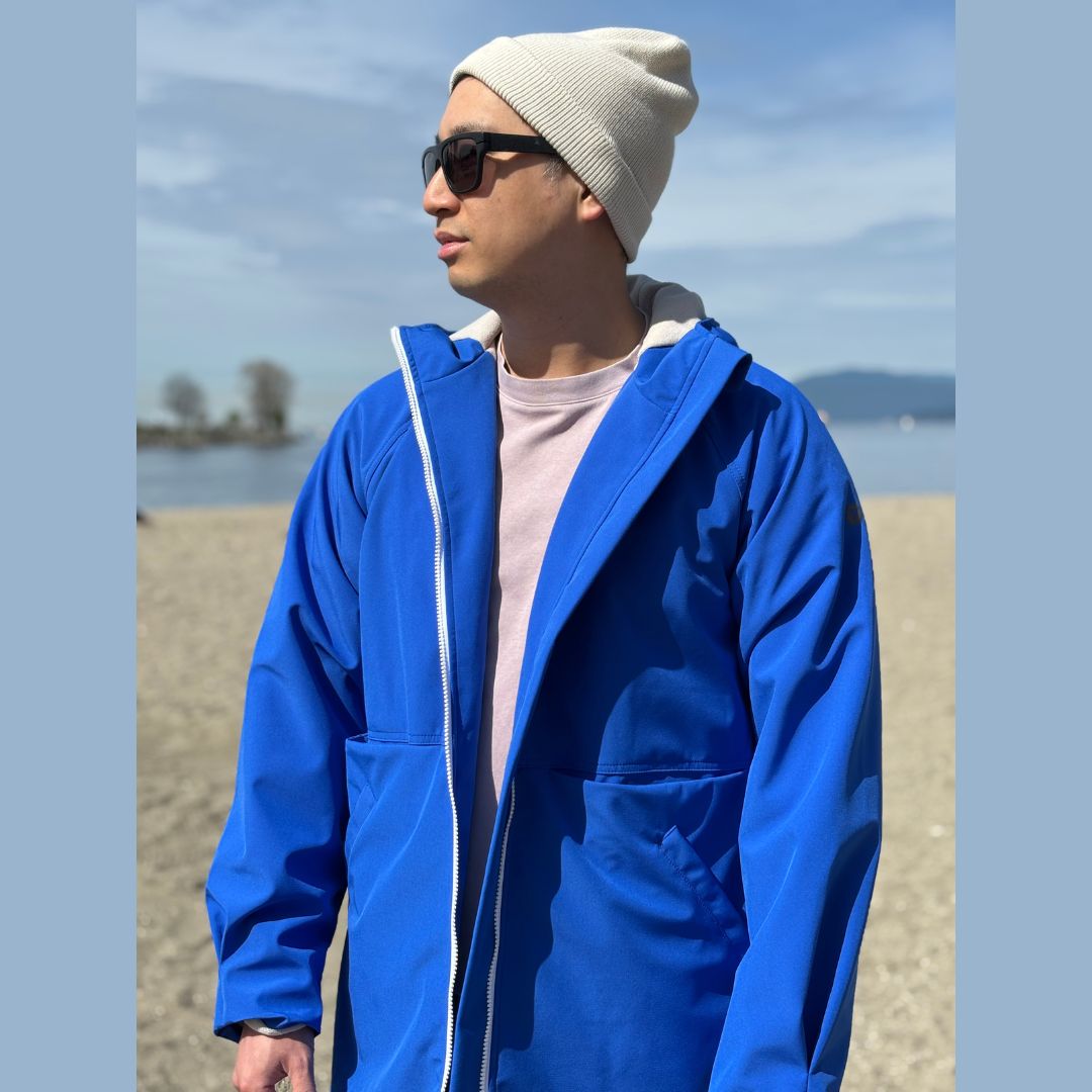 A male swimmer wears a Tingting swim parka sPARKA Fly on top of a pink t shirt.