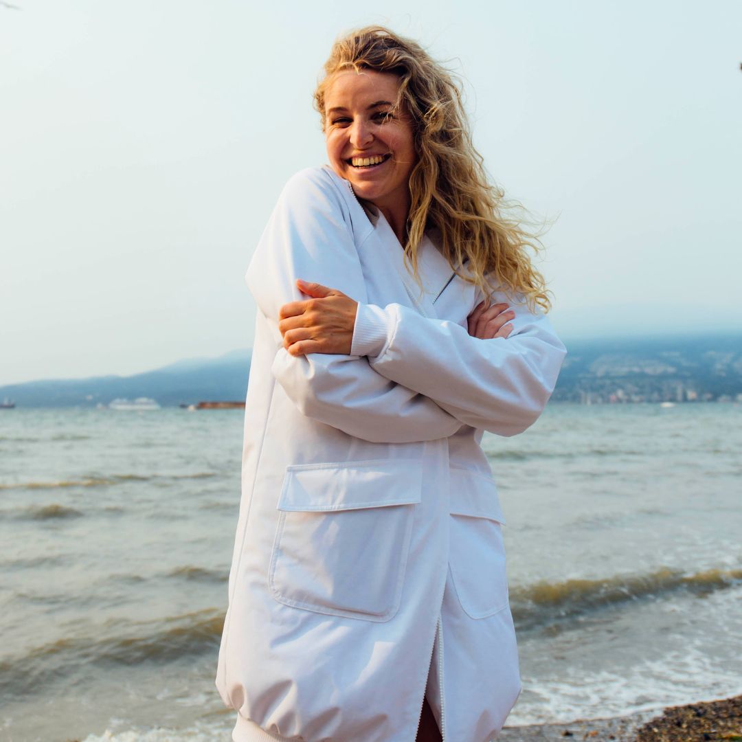 Triathlete Bronwyn Davies models white swim parka at Kits Beach Vancouver