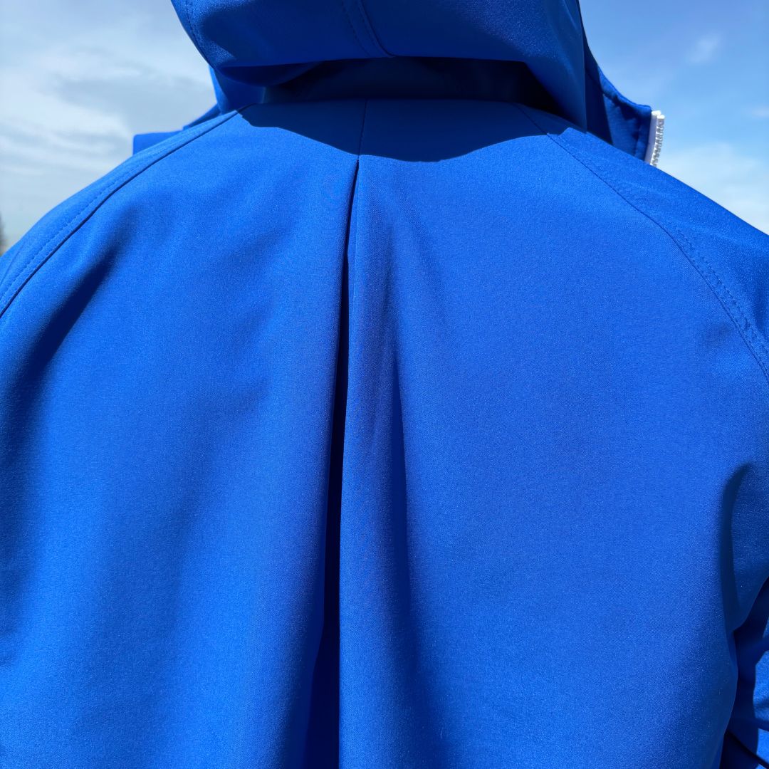 A close up view of the back side of the Tingting swim parka | sPARKA Fly in blue. There's a pleat detail on the upper back, which is designed to increase the comfort for the swimmer.