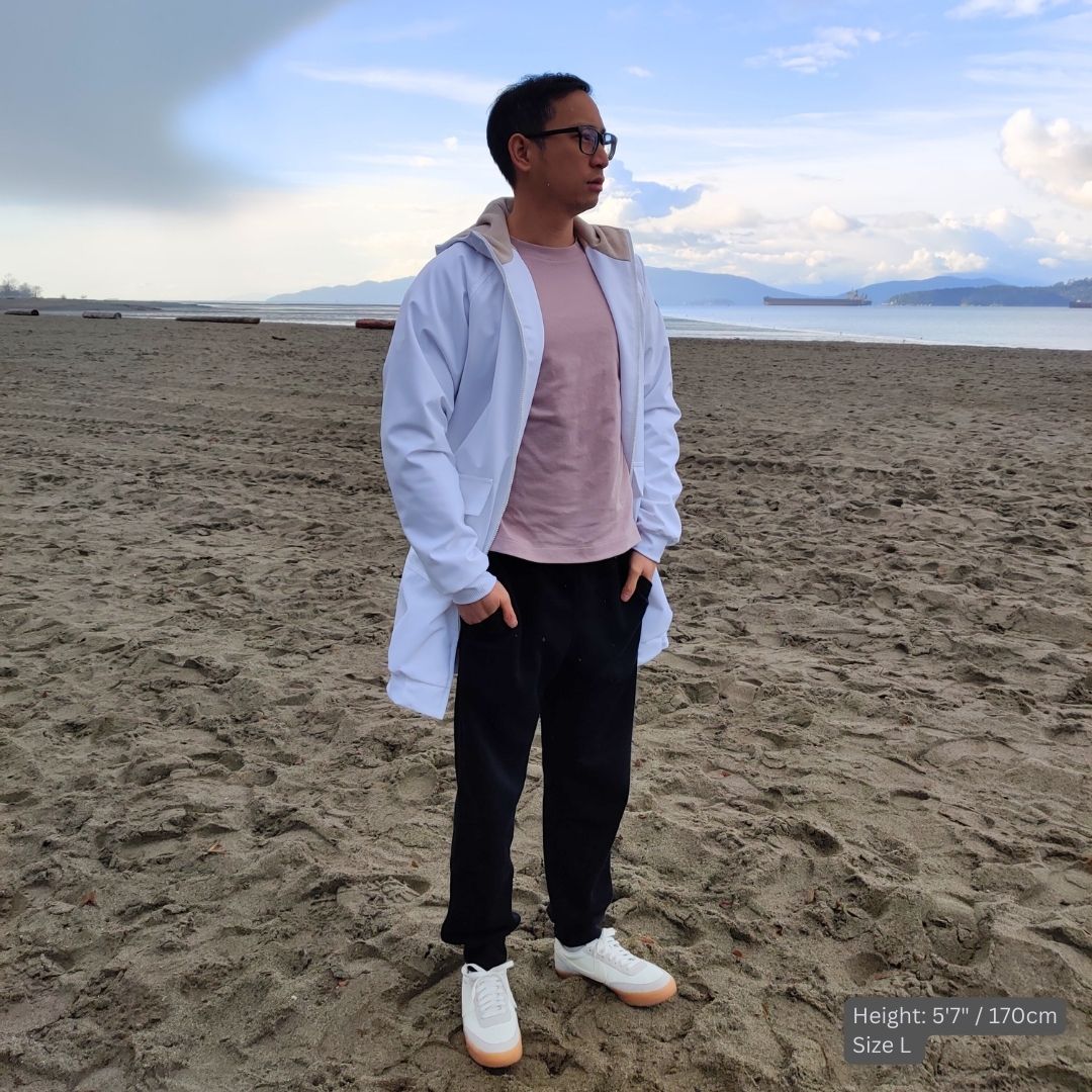 Male model wears white swim parka at the beach