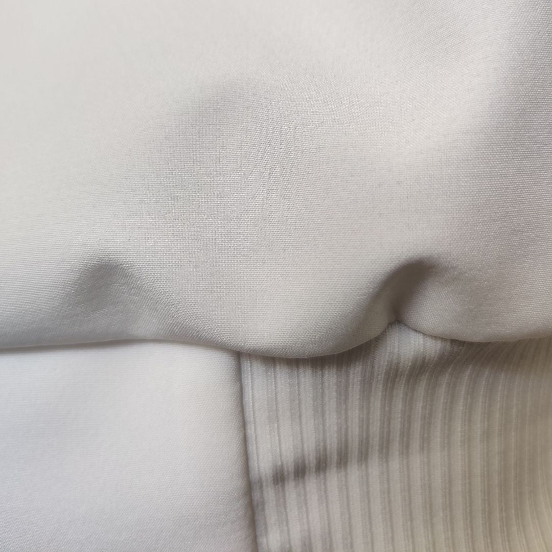Waist band (ribbing) of a white swim parka