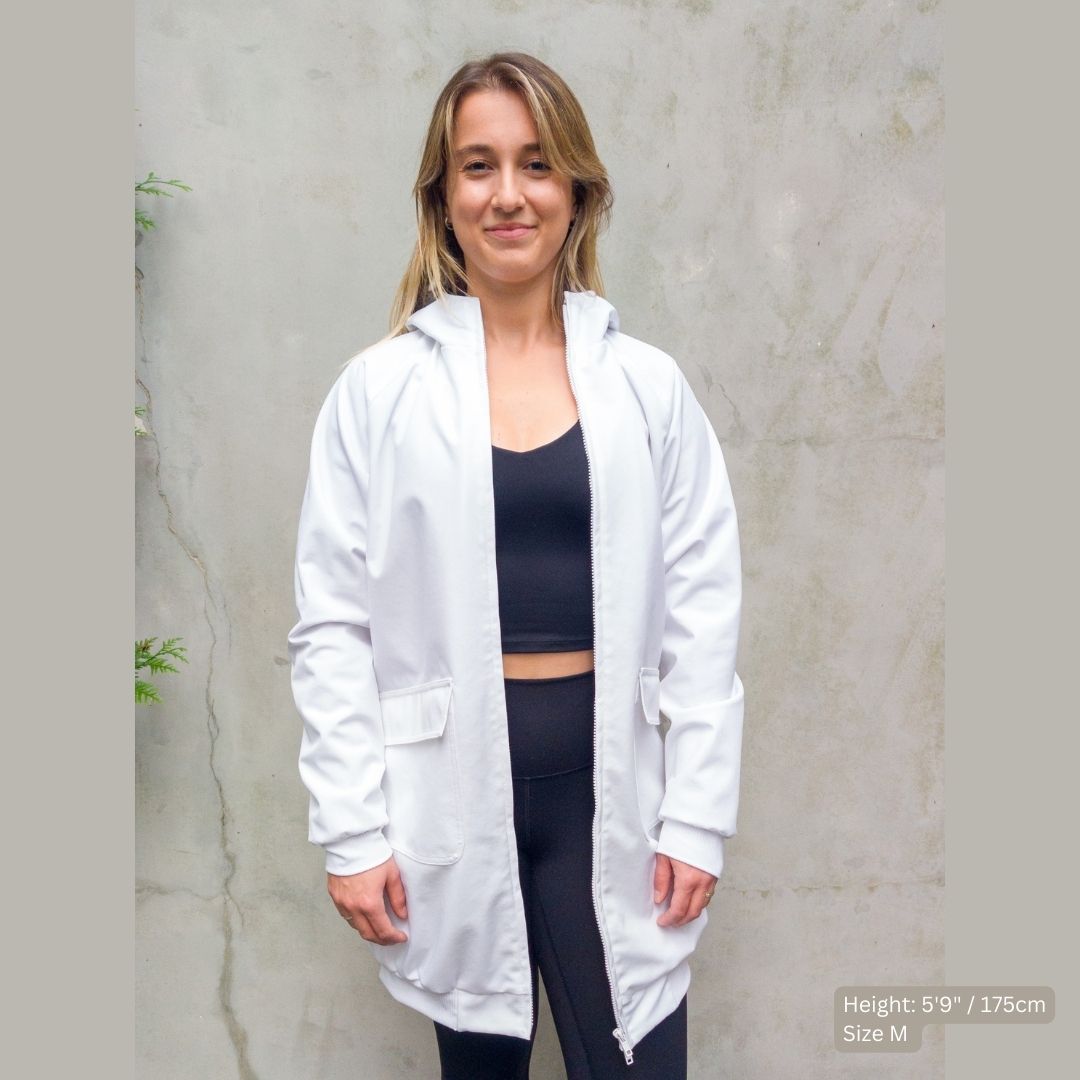 Female Model pairs a white swim parka with black outfit