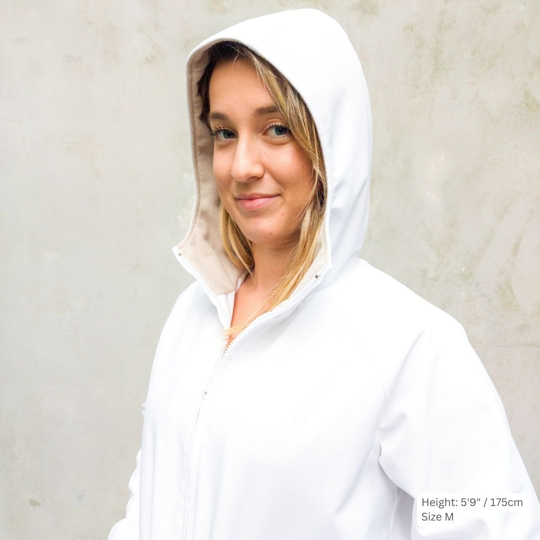 Female model wears a white swim parka with the hood up